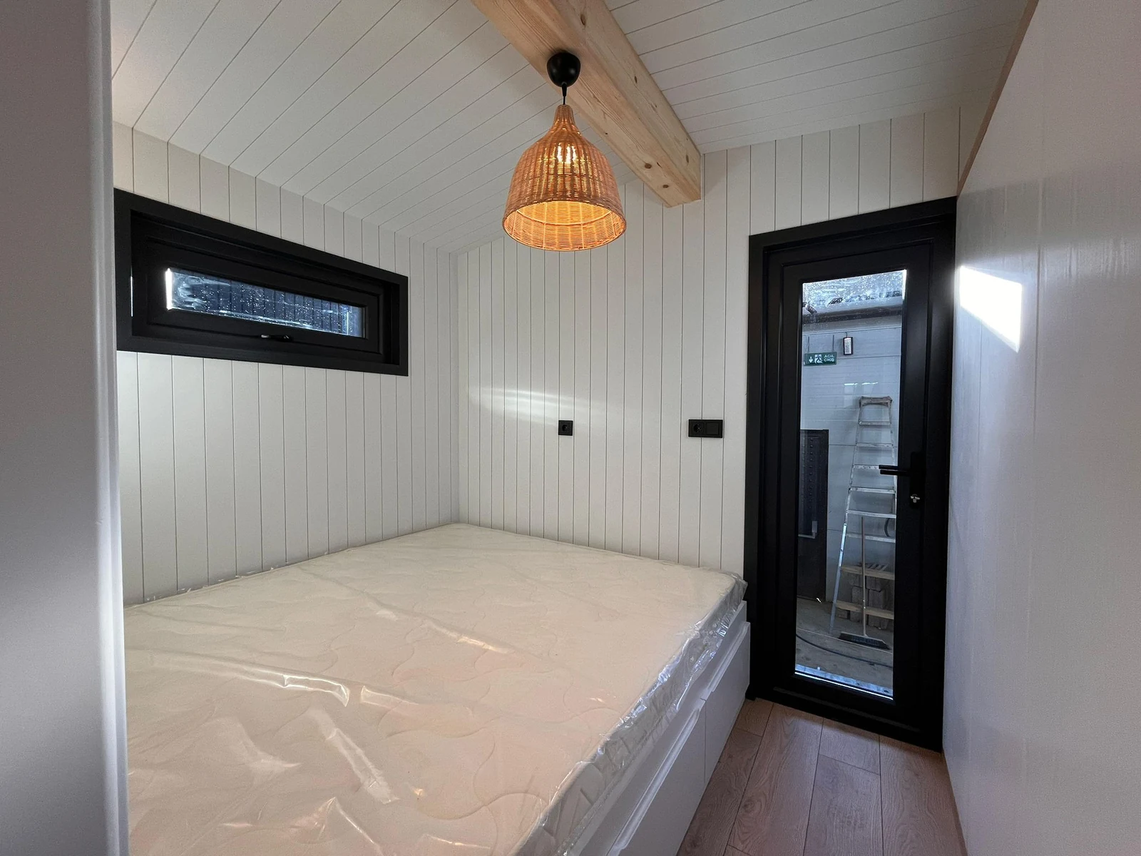 Chaletslaapkamer met houten balk en hanglamp