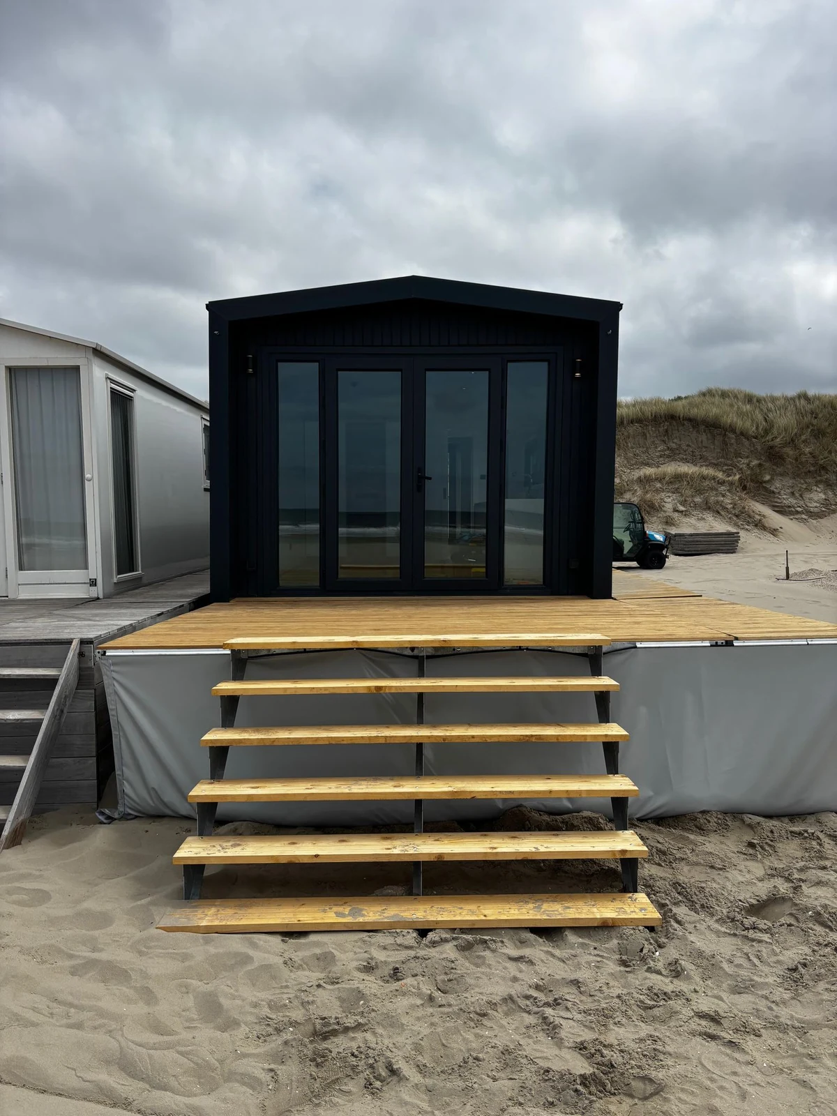 Donker chalet met houten toegang op een strandlocatie