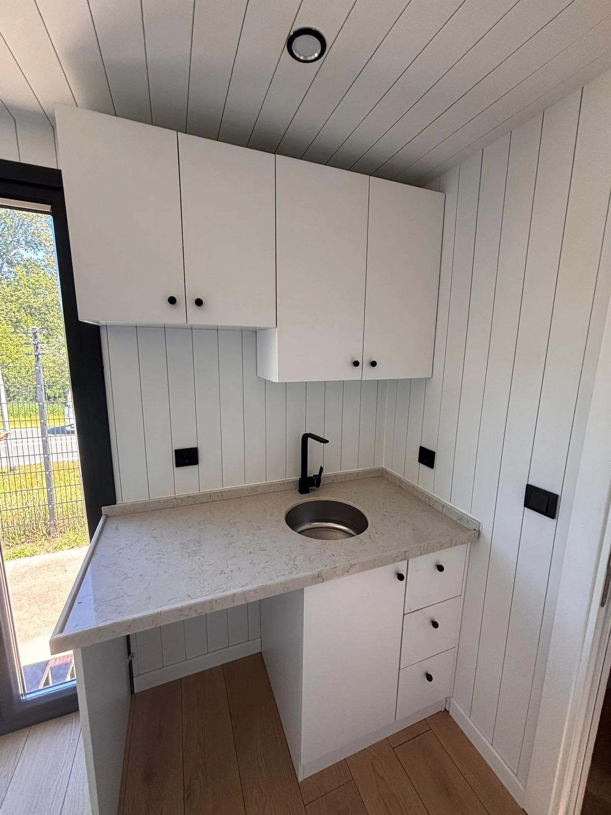 Keuken van de Sunset Lodge 660 met spoelkom en lichte wandpanelen